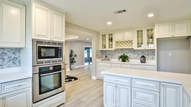 18971 Birch St, Perris, CA 92570 - kitchen with stainless steel appliances, tasteful backsplash, light wood finished floors, light countertops, and recessed lighting