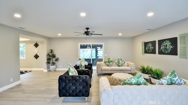 living area featuring light wood-style flooring, baseboards, and recessed lighting