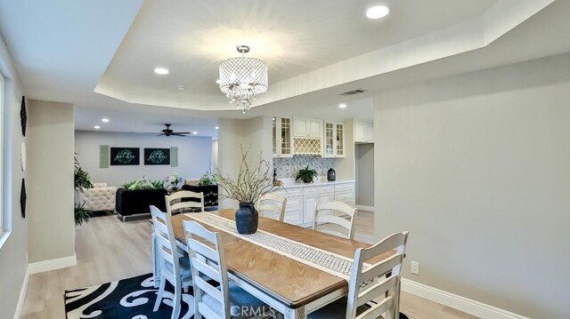 18971 Birch St, Perris, CA 92570 - dining area with light wood-style floors, baseboards, a chandelier, recessed lighting, and a tray ceiling