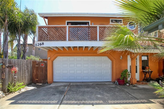 1268 Baden Ave, Grover Beach, CA 93433 - view of front of house with a garage, concrete driveway, a balcony, and fence