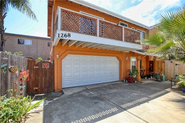 1268 Baden Ave, Grover Beach, CA 93433 - view of front of property with driveway, fence, a garage, a balcony, and stucco siding