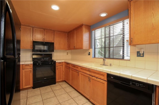 1268 Baden Ave, Grover Beach, CA 93433 - kitchen with tile counters, light tile patterned floors, a sink, black appliances, and tasteful backsplash