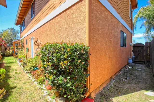 1268 Baden Ave, Grover Beach, CA 93433 - view of side of property with a gate, a lawn, stucco siding, and fence