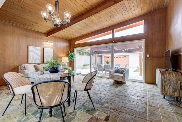 dining area featuring stone tile floors, wooden walls, beam ceiling, wood ceiling, and a notable chandelier