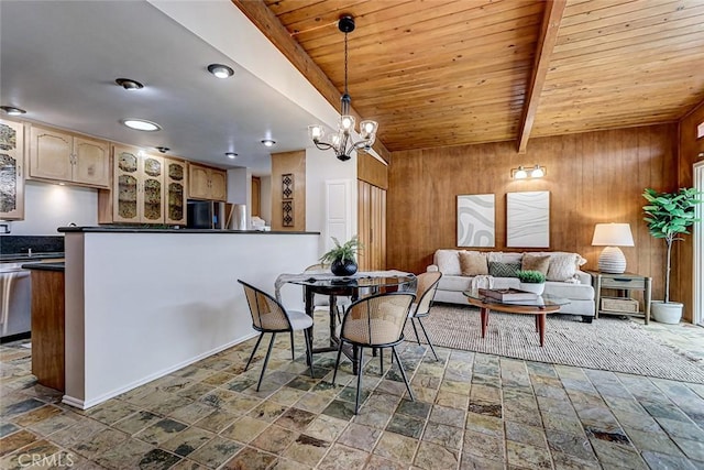 dining area with stone tile floors, wooden walls, wood ceiling, an inviting chandelier, and beamed ceiling
