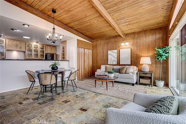living area with stone tile floors, wood walls, an inviting chandelier, beamed ceiling, and wood ceiling
