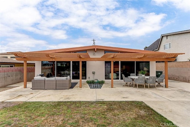back of house featuring fence, a pergola, an outdoor hangout area, and stucco siding