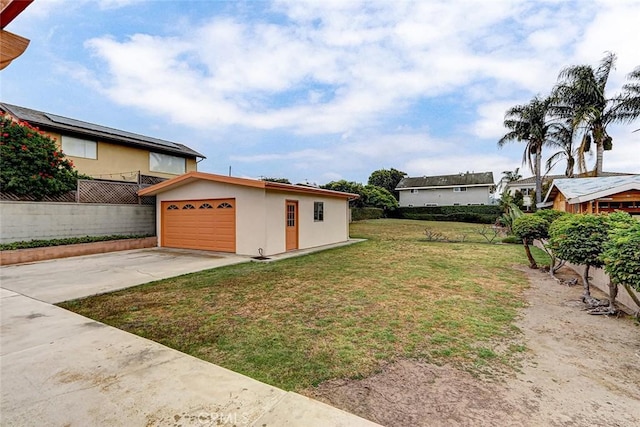 view of yard featuring concrete driveway and fence