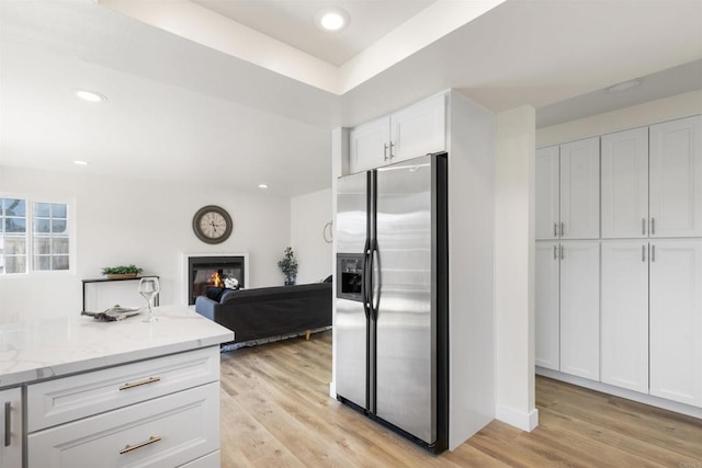 1194 Erin Dr, El Cajon, CA 92020 - kitchen featuring light stone countertops, a glass covered fireplace, light wood-style flooring, stainless steel refrigerator with ice dispenser, and white cabinetry