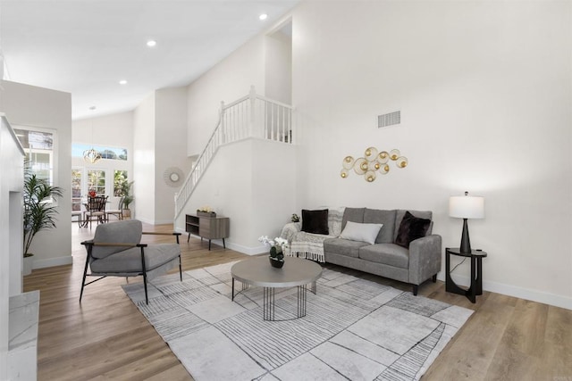 1194 Erin Dr, El Cajon, CA 92020 - living room featuring stairway, high vaulted ceiling, wood finished floors, baseboards, and visible vents