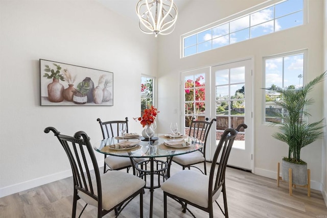 1194 Erin Dr, El Cajon, CA 92020 - dining space with a chandelier, light wood-type flooring, a towering ceiling, and baseboards