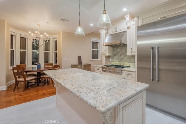 3499 Viewfield Ave, Hacienda Heights, CA 91745 - kitchen featuring under cabinet range hood, light stone counters, backsplash, stainless steel appliances, and a chandelier