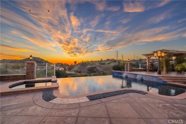 3499 Viewfield Ave, Hacienda Heights, CA 91745 - pool at dusk featuring a patio area, an infinity pool, and an in ground hot tub