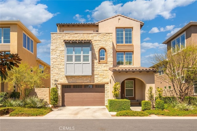 mediterranean / spanish-style home featuring stucco siding, a garage, a tile roof, stone siding, and concrete driveway
