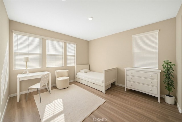 bedroom with light wood-type flooring and baseboards