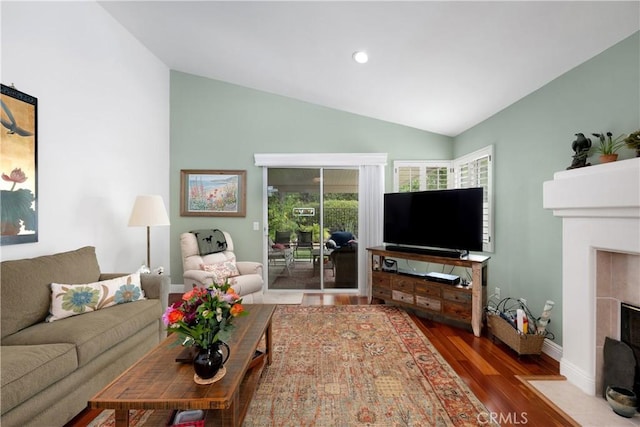 living area with recessed lighting, wood finished floors, a fireplace, baseboards, and lofted ceiling