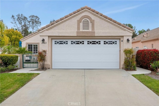 view of front of home featuring stucco siding, fence, an outbuilding, a garage, and concrete driveway