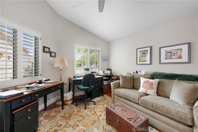 office space featuring a ceiling fan, baseboards, lofted ceiling, and light wood-type flooring
