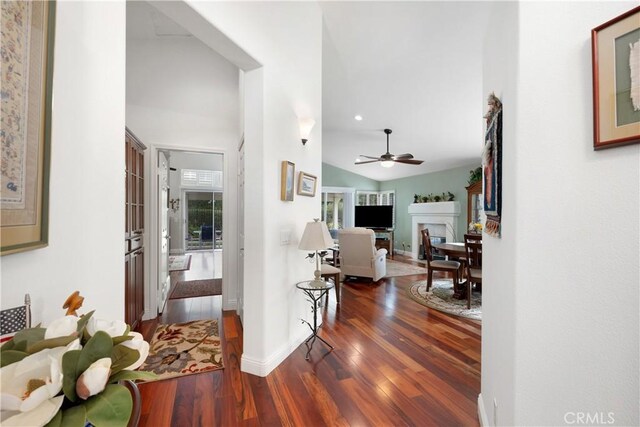 corridor featuring recessed lighting, lofted ceiling, wood finished floors, and baseboards