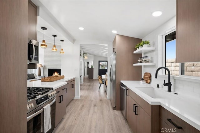432 Seville Ave, Newport Beach, CA 92661 - kitchen with light wood finished floors, stainless steel appliances, light countertops, open shelves, and a fireplace
