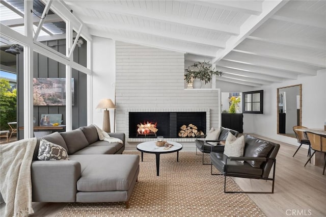 432 Seville Ave, Newport Beach, CA 92661 - living area with a brick fireplace, wood finished floors, vaulted ceiling with beams, and plenty of natural light