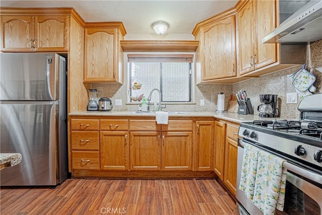 791 W 2nd St, San Pedro, CA 90731 - kitchen featuring appliances with stainless steel finishes, range hood, a sink, light wood-style flooring, and light countertops