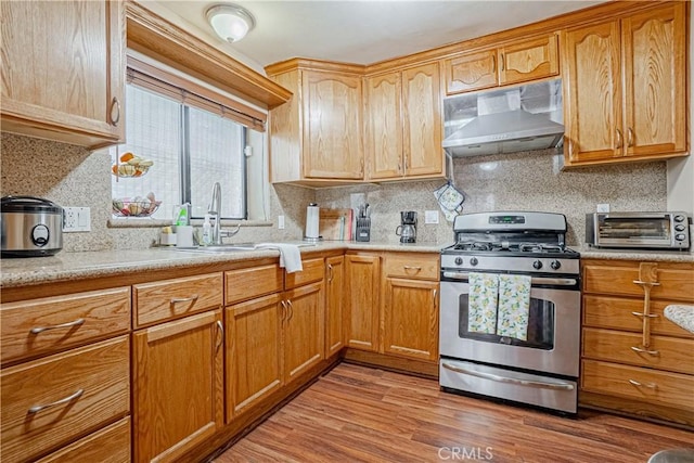 791 W 2nd St, San Pedro, CA 90731 - kitchen featuring stainless steel gas range, range hood, light wood-style floors, tasteful backsplash, and a sink