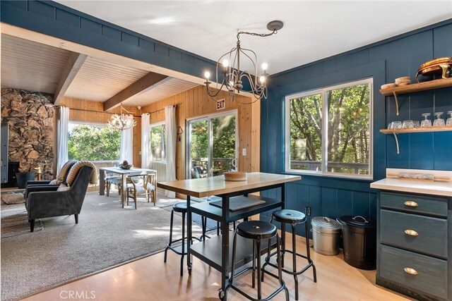 27979 N Bay Rd, Lake Arrowhead, CA 92352 - dining room with an inviting chandelier, beam ceiling, wooden walls, and light wood-style flooring