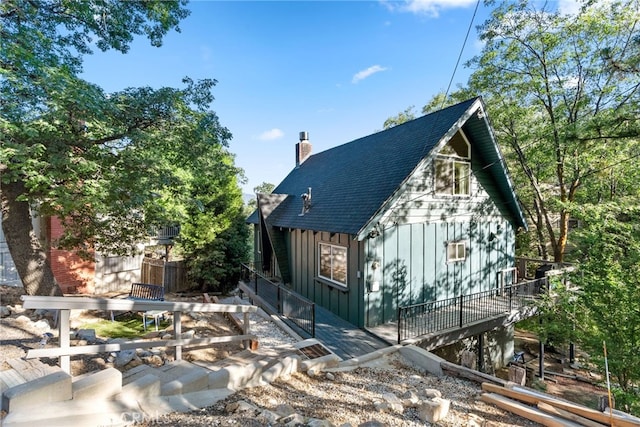 27979 N Bay Rd, Lake Arrowhead, CA 92352 - view of home's exterior with board and batten siding, a shingled roof, and a chimney