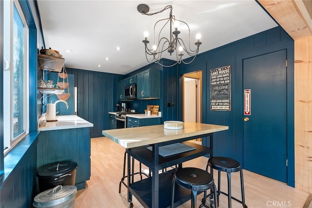 27979 N Bay Rd, Lake Arrowhead, CA 92352 - kitchen featuring light countertops, an inviting chandelier, stainless steel appliances, light wood-style flooring, and blue cabinetry