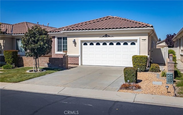 1765 Desert Poppy Ln, Beaumont, CA 92223 - mediterranean / spanish house with concrete driveway, a garage, a tile roof, and stucco siding