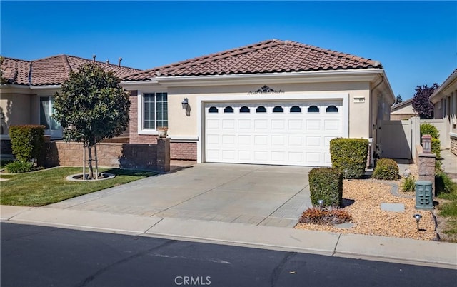1765 Desert Poppy Ln, Beaumont, CA 92223 - mediterranean / spanish house featuring concrete driveway, a garage, a tiled roof, and stucco siding