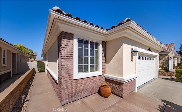 1765 Desert Poppy Ln, Beaumont, CA 92223 - view of front of property with stucco siding, concrete driveway, brick siding, a garage, and fence