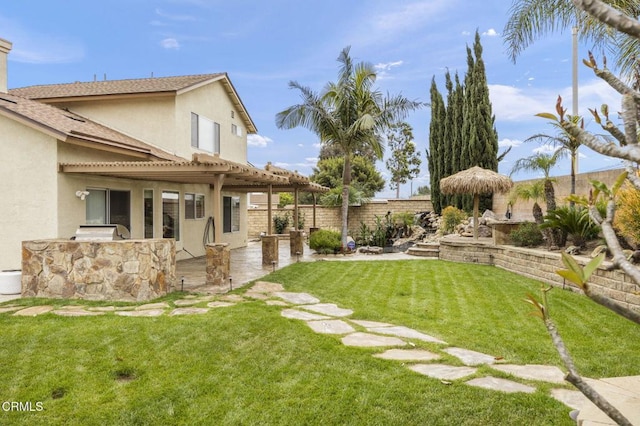 view of yard featuring a pergola, an outdoor kitchen, a patio, and a fenced backyard