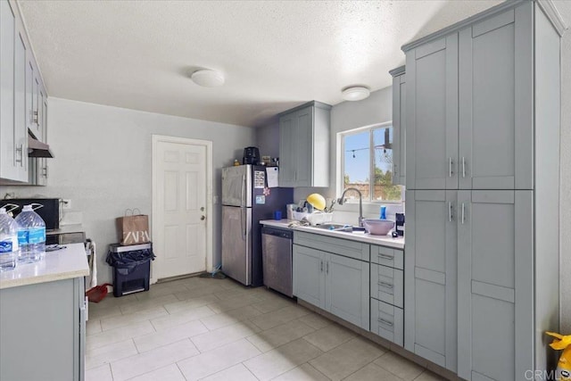 111 69th St, San Diego, CA 92114 - kitchen featuring appliances with stainless steel finishes, gray cabinetry, light countertops, under cabinet range hood, and a textured ceiling
