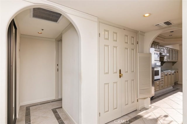 345 Pioneer Dr Unit 1705, Glendale, CA 91203 - corridor with inlaid floor details, baseboards, recessed lighting, arched walkways, and light tile patterned flooring