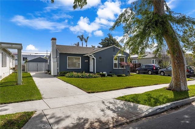 bungalow-style house featuring a gate, driveway, a chimney, a front yard, and stucco siding