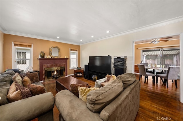 living room featuring dark wood-style floors, a fireplace, recessed lighting, and ornamental molding