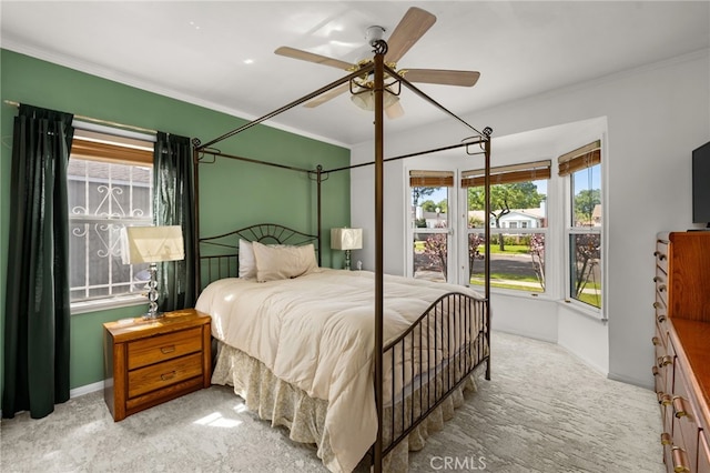 carpeted bedroom with a ceiling fan, baseboards, and ornamental molding