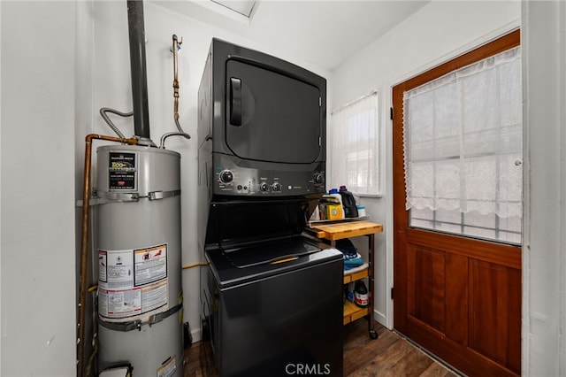 laundry room featuring stacked washer / drying machine, dark wood finished floors, strapped water heater, and laundry area