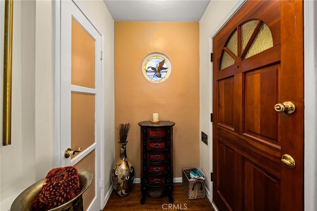doorway featuring dark wood-type flooring and baseboards