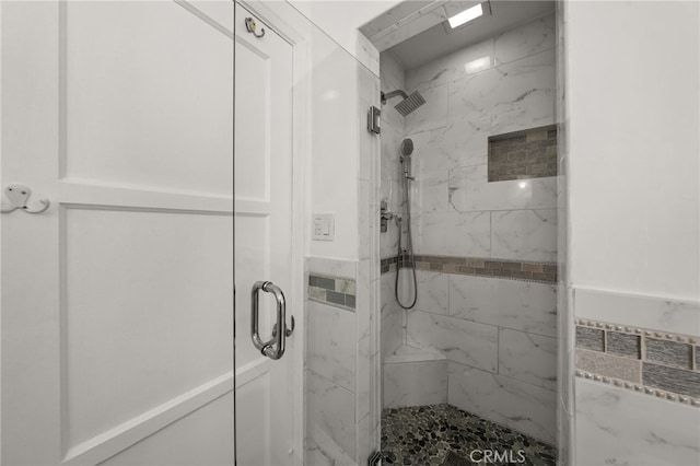 bathroom featuring a marble finish shower