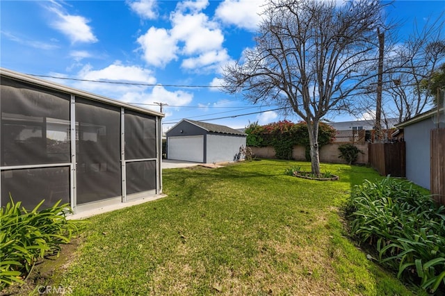 view of yard featuring an outdoor structure, a sunroom, a detached garage, and fence private yard