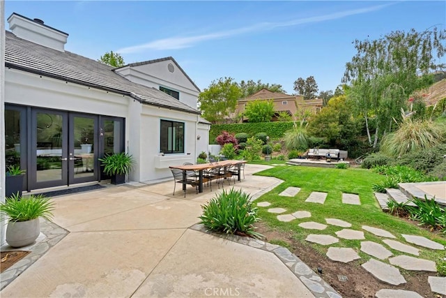 view of yard with french doors, outdoor dining area, and a patio area
