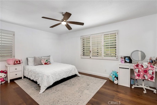 bedroom with ceiling fan, baseboards, and dark wood finished floors