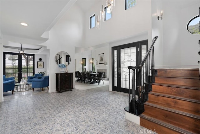 foyer with a high ceiling, stairway, french doors, and baseboards