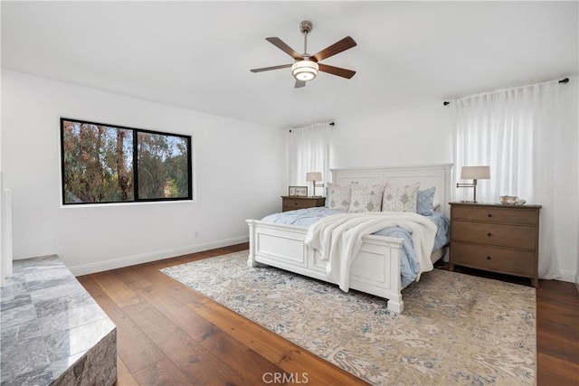 bedroom featuring wood finished floors, ceiling fan, and baseboards