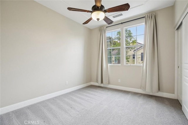 carpeted spare room with ceiling fan, baseboards, and visible vents