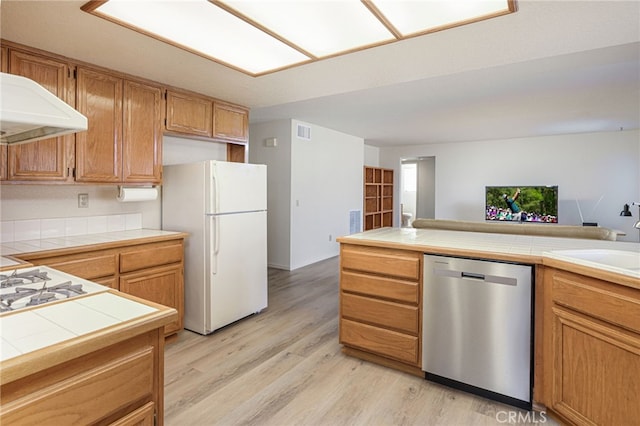 6721 Silver Oak Pl, Riverside, CA 92506 - kitchen with stainless steel dishwasher, a sink, freestanding refrigerator, light wood-style floors, and tile countertops