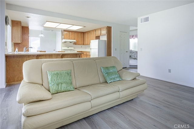 6721 Silver Oak Pl, Riverside, CA 92506 - living room featuring baseboards, light wood-style flooring, visible vents, and an inviting chandelier
